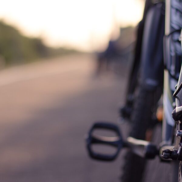A close-up shot of bicycle wheels aligned on a street, with a shallow depth of field blurring the background.