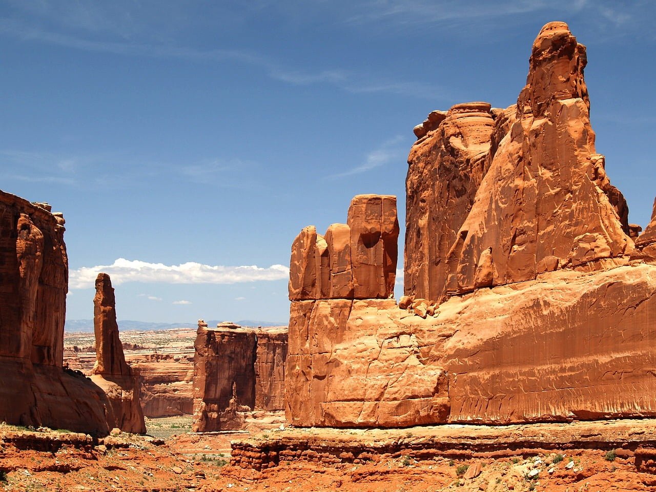 Red sandstone rock formations with a clear blue sky in Arches National Park.