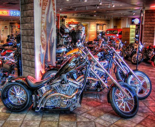 A vibrant, HDR-enhanced photo of a showroom featuring a variety of motorcycles with chrome details and reflections on the polished floor.